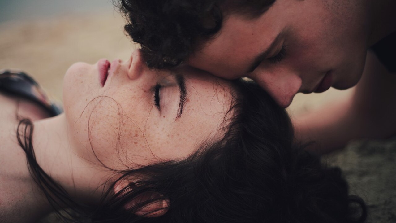 İki çift gözleri kapalı erkek kadını alnından öpüyor ve kadın yerde uzanıyor