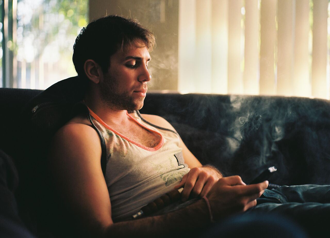 Erkek, bir kadına telefon elinde mesaj gönderiyor ve koltukta uzanıyor